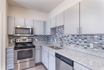 A kitchen with a stove, oven, microwave, and dishwasher.